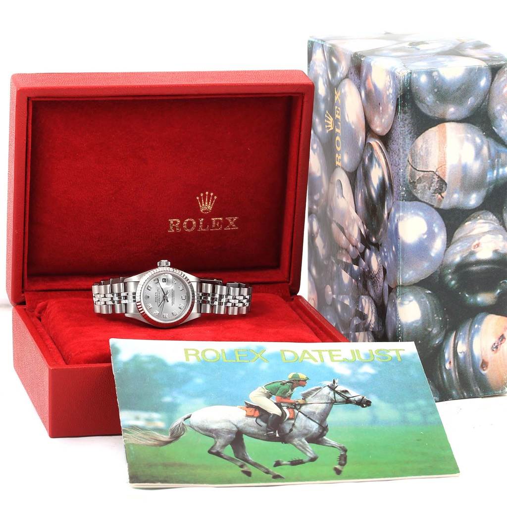 The Rolex Datejust 79174 Women's Stainless Steel Silver Dial 79174 Women's Stainless Steel Silver Dial watch is displayed front-on in an open red case, with its manual and outer packaging visible.