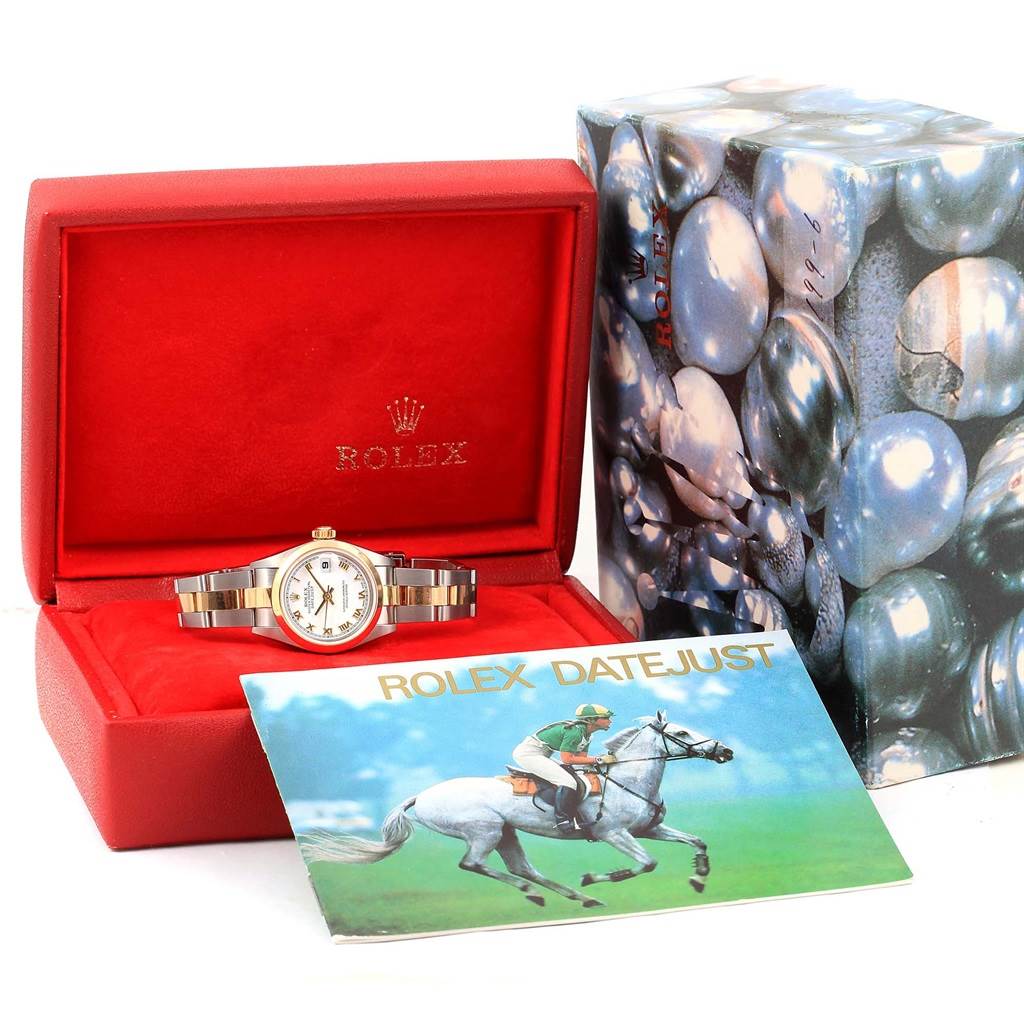 The Rolex Datejust 79163 Women's Steel and Gold (two tone) White Dial 79163 Women's Steel and Gold (two tone) White Dial watch is displayed in an open red box with its band visible, alongside a pamphlet and decorative outer box.
