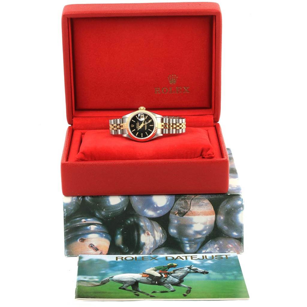 The image shows a Rolex Datejust 79173 Women's Steel and Gold (two tone) Black Dial 79173 Women's Steel and Gold (two tone) Black Dial watch displayed in its red case with the manual in front.