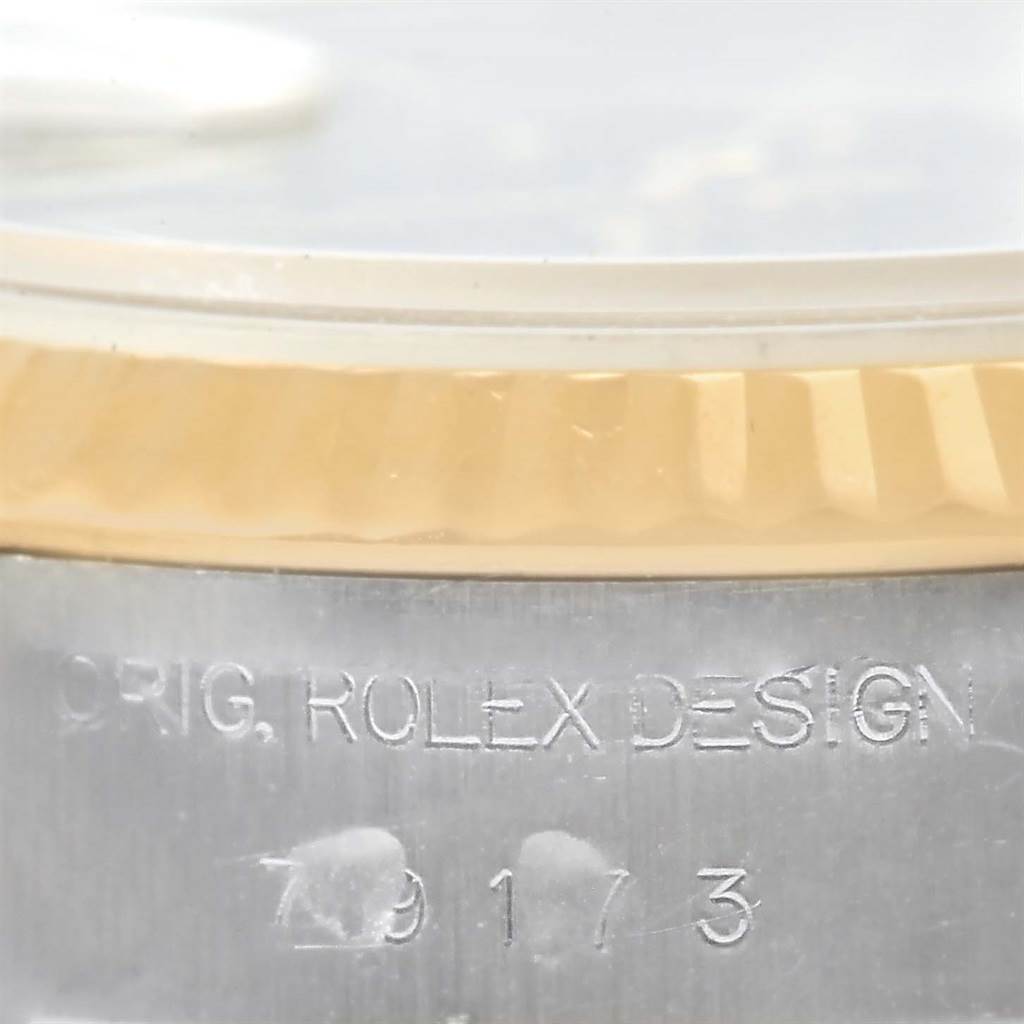 The image shows a close-up of the side of a Rolex Datejust 79173 Women's Steel and Gold (two tone) Black Dial 79173 Women's Steel and Gold (two tone) Black Dial watch, showcasing the fluted bezel and engraved case.
