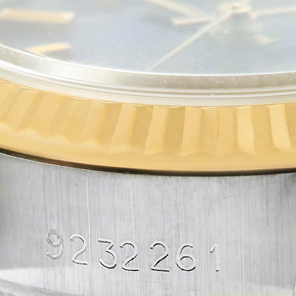 This close-up of the Rolex Datejust 69173 Women's Stainless Steel Blue Dial 69173 Women's Stainless Steel Blue Dial watch shows part of the gold bezel and case with the model number engraved.