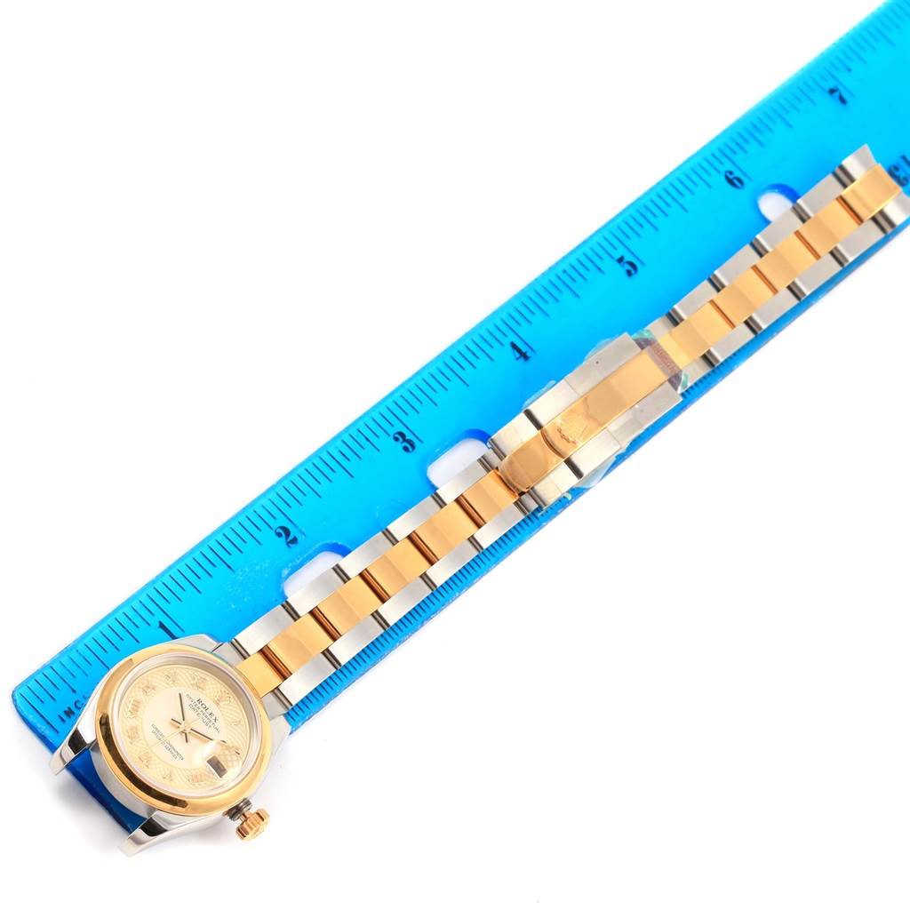 A Rolex Datejust 179163 Women's Stainless Steel Mother of Pearl Dial 179163 Women's Stainless Steel Mother of Pearl Dial watch is shown from a top-down angle beside a ruler, highlighting its gold and steel bracelet.