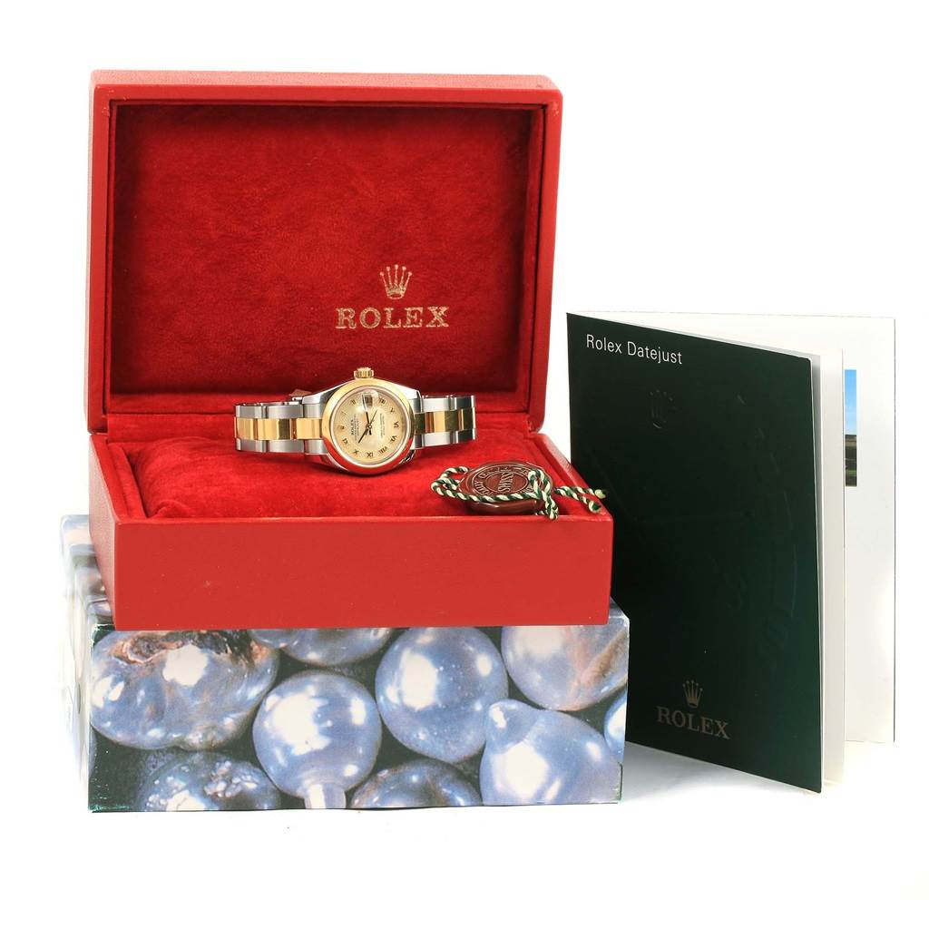 The Rolex Datejust 179163 Women's Stainless Steel Mother of Pearl Dial 179163 Women's Stainless Steel Mother of Pearl Dial watch is displayed inside a red box with its booklet and tag beside it.