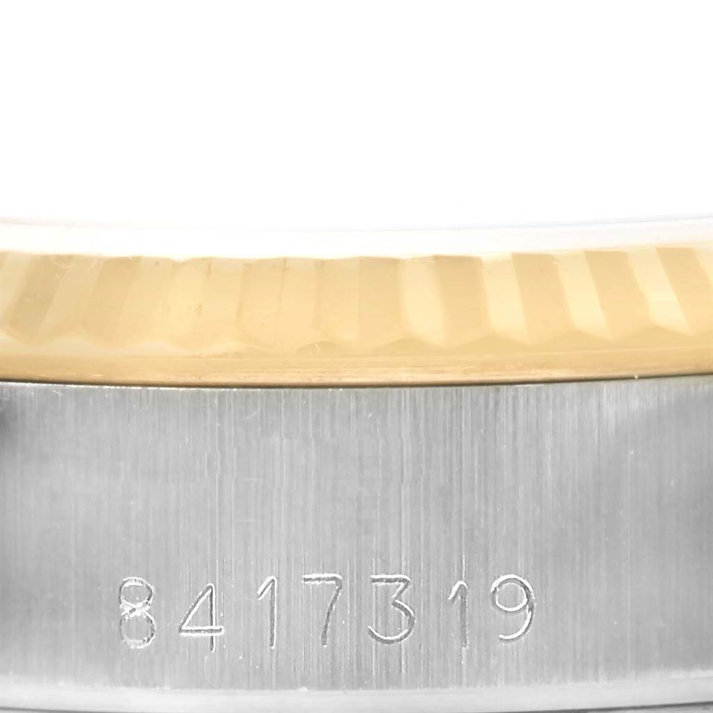This image shows a close-up of the serial number and fluted bezel on a Rolex Datejust 69173 Women's Stainless Steel Champagne Dial 69173 Women's Stainless Steel Champagne Dial watch.