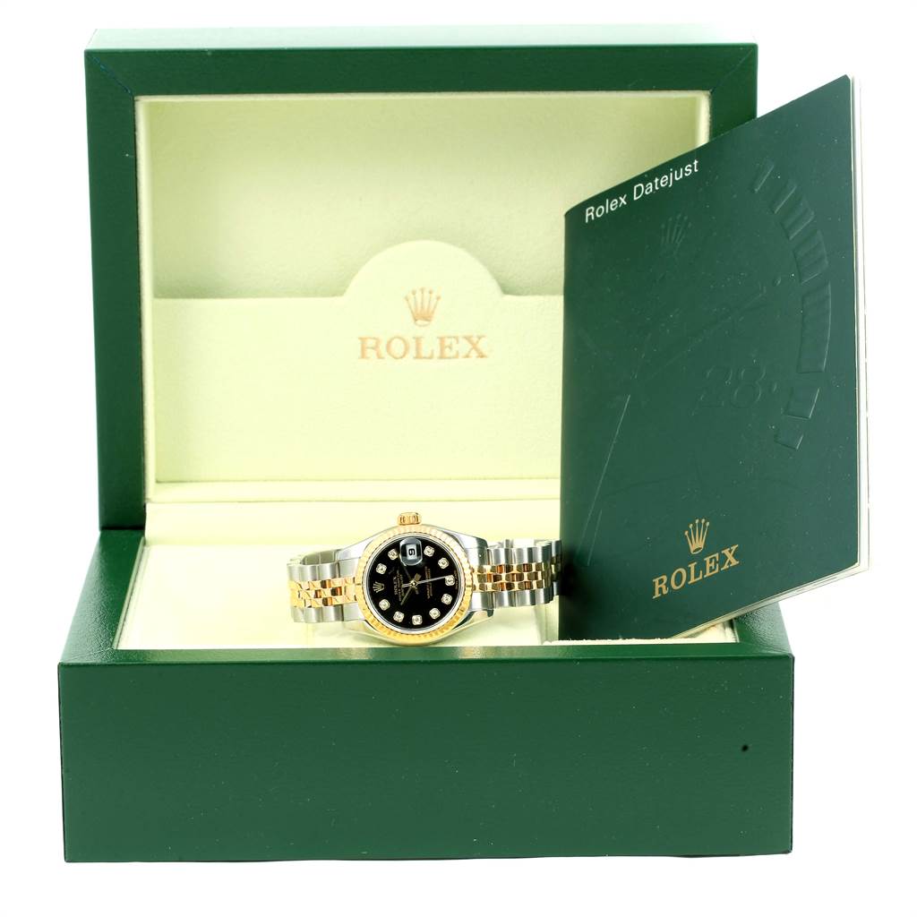 The image shows a Rolex Datejust 179173 Women
s Steel and Gold (two tone) Black Dial 179173 Women
s Steel and Gold (two tone) Black Dial watch in its green box with an open instruction booklet on the right.