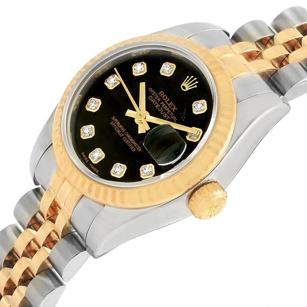 The image shows a close-up of a Rolex Datejust 179173 Women
s Steel and Gold (two tone) Black Dial 179173 Women
s Steel and Gold (two tone) Black Dial watch, highlighting its black dial, diamond hour markers, gold bezel, and two-tone bracelet.
