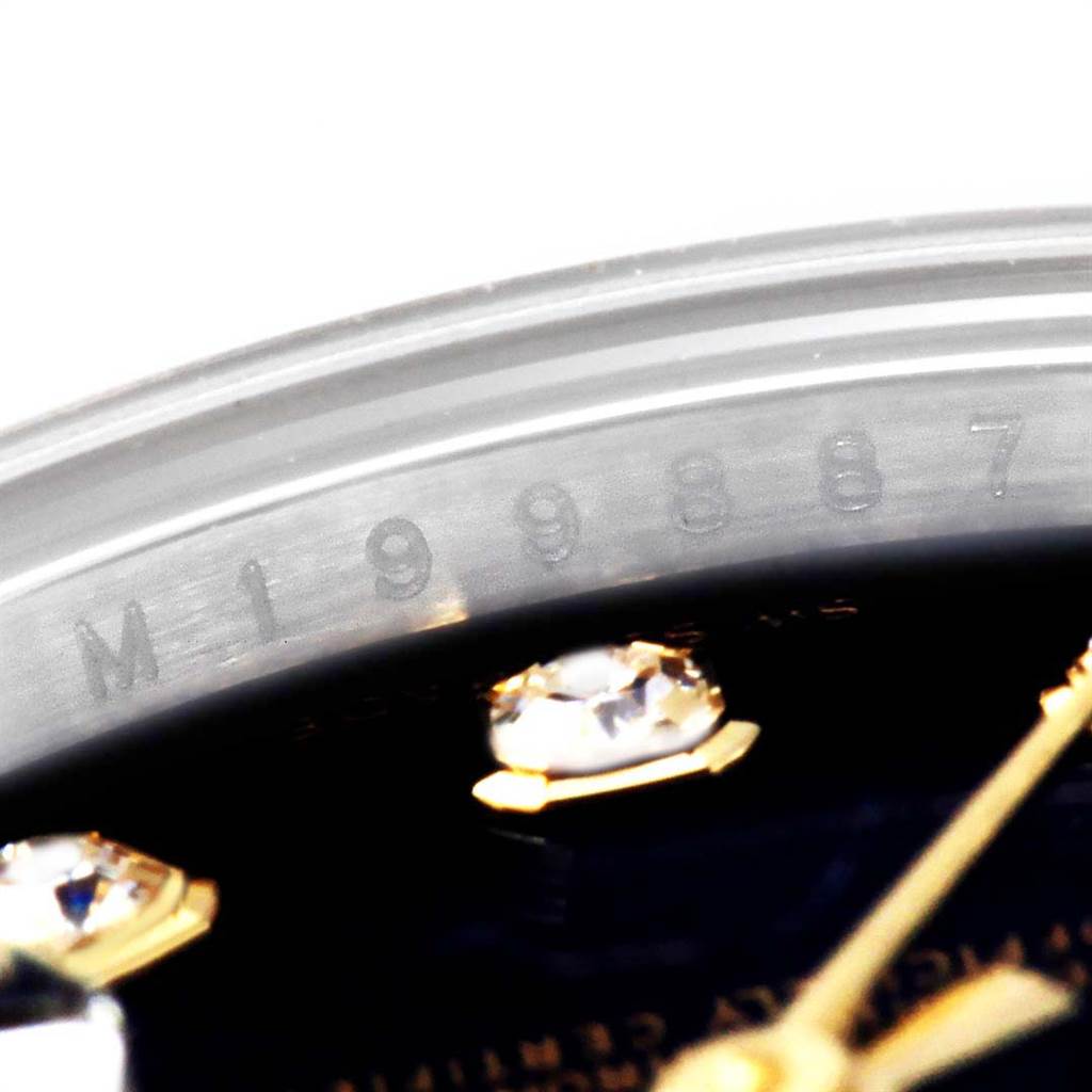 This close-up image of a Rolex Datejust 179173 Women
s Steel and Gold (two tone) Black Dial 179173 Women
s Steel and Gold (two tone) Black Dial watch shows the serial number engraved on the inner bezel and parts of the dial.