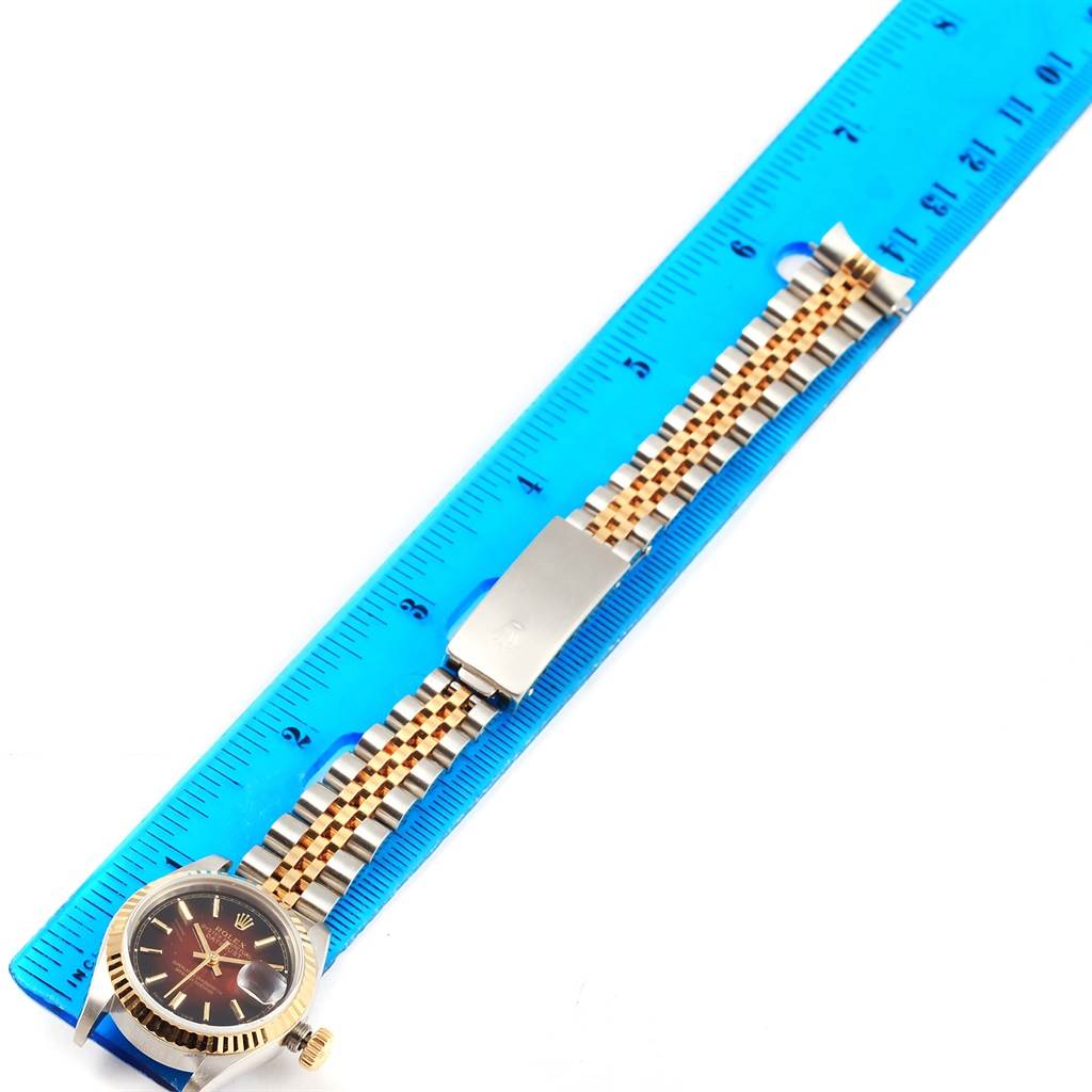 The image shows a Rolex Datejust 69173 Women's Stainless Steel Brown Dial 69173 Women's Stainless Steel Brown Dial watch and its bracelet, laid flat next to a blue ruler for measurement.