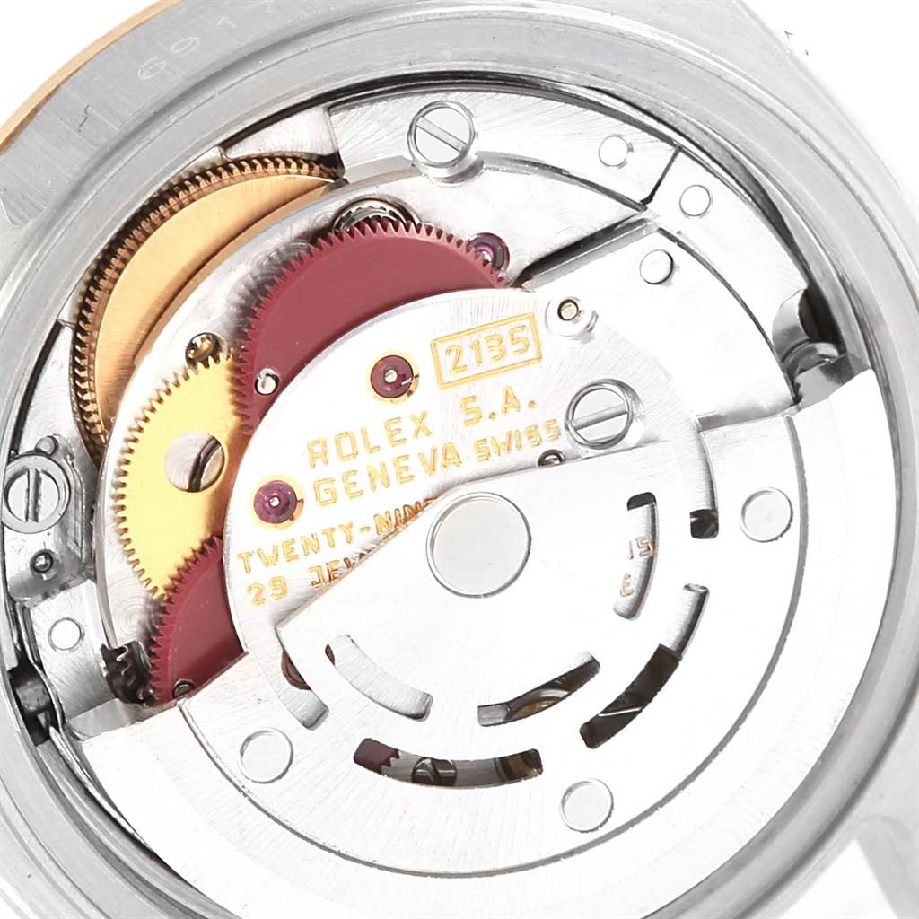 The image shows the internal movement mechanism of a Rolex Datejust 69173 Women's Stainless Steel Brown Dial 69173 Women's Stainless Steel Brown Dial watch, highlighting gears and other intricate components.