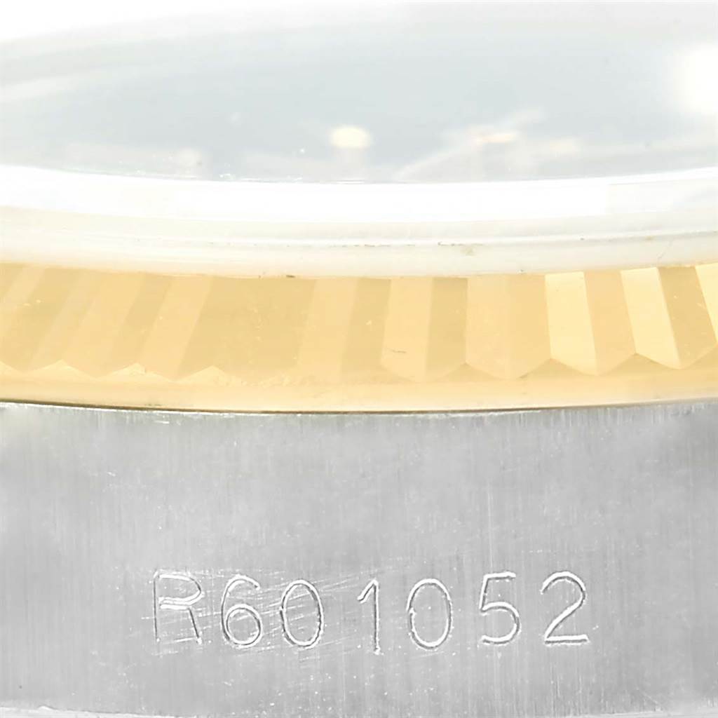 The image shows a close-up angle of the Rolex Datejust 69173 Women's Stainless Steel Brown Dial 69173 Women's Stainless Steel Brown Dial's bezel and part of the case with a serial number engraved on the side.