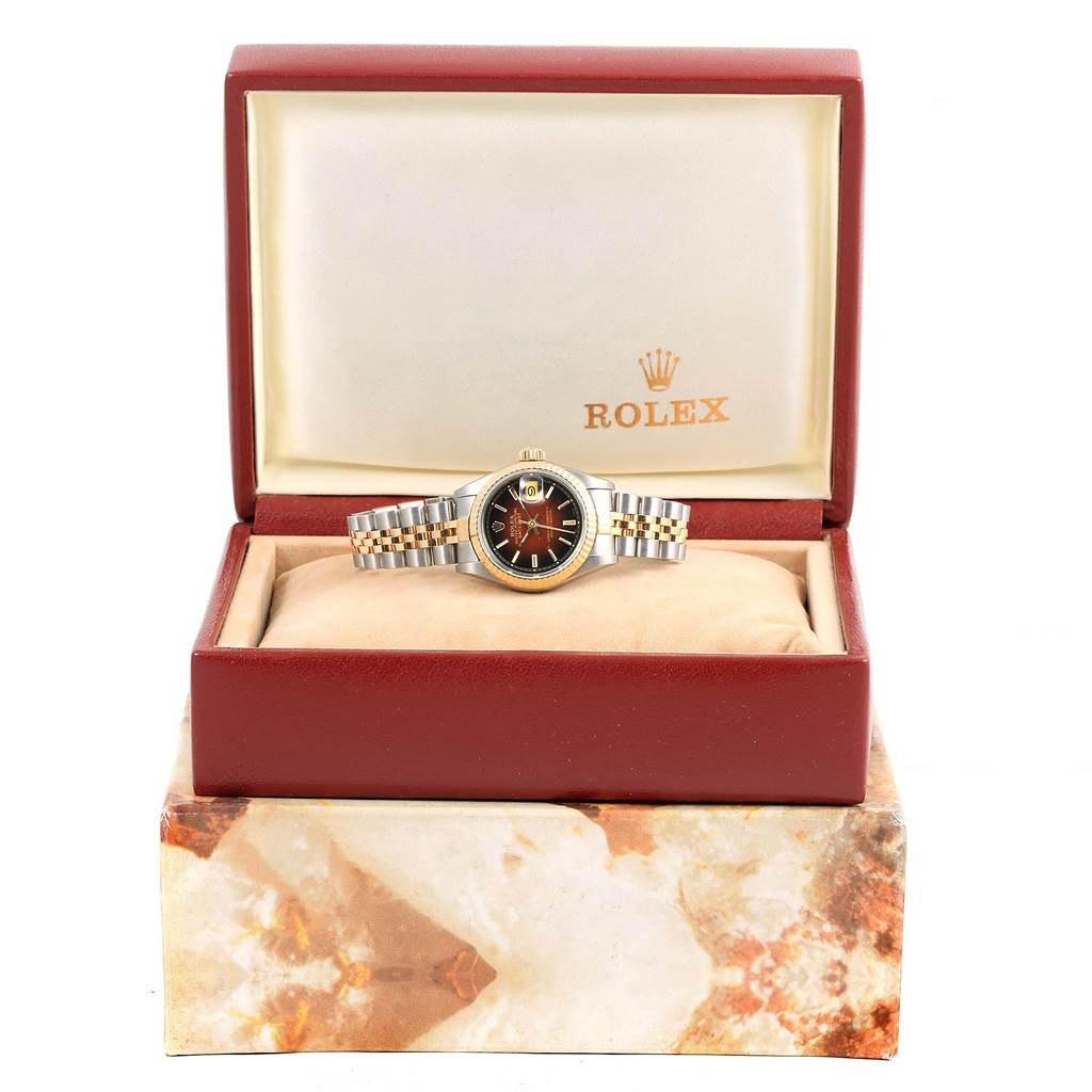 The Rolex Datejust 69173 Women's Stainless Steel Brown Dial 69173 Women's Stainless Steel Brown Dial watch is displayed front-on inside a red and beige Rolex box.