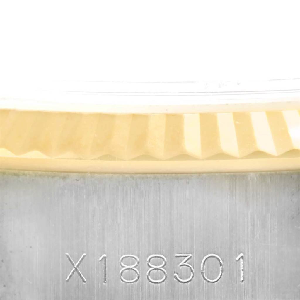 This close-up image shows part of the fluted bezel and serial number on the side of a Rolex Datejust 69173 Women's Stainless Steel Champagne Dial 69173 Women's Stainless Steel Champagne Dial watch.