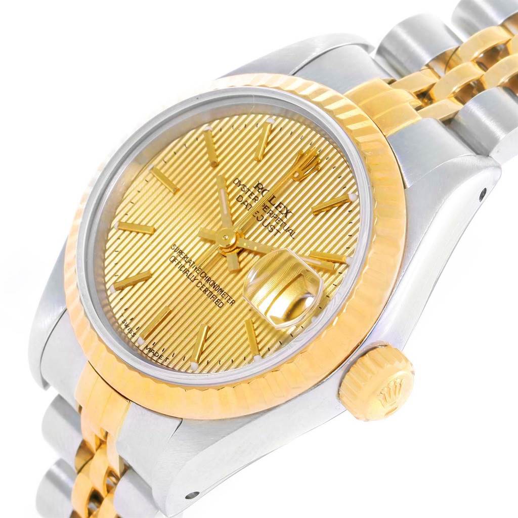 The image shows a close-up of the Rolex Datejust 69173 Women's Stainless Steel Champagne Dial 69173 Women's Stainless Steel Champagne Dial watch, highlighting its gold dial, fluted bezel, and two-tone bracelet.