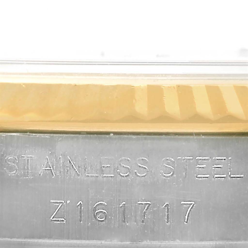 This close-up image shows the serial number engraved on the stainless steel case and the edge of the bezel of a Rolex Datejust 179173 Women's Steel and Gold (two tone) Silver Dial 179173 Women's Steel and Gold (two tone) Silver Dial watch.