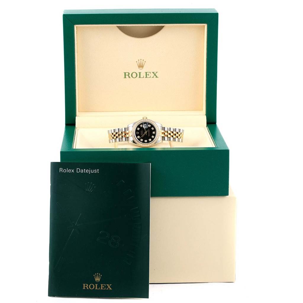 The Rolex Datejust 179383 Women's Steel and Gold (two tone) Black Dial 179383 Women's Steel and Gold (two tone) Black Dial watch is shown front-facing in an open box with a manual positioned in front.