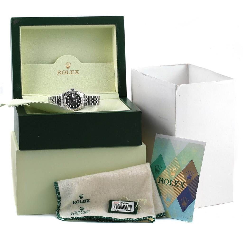 The image shows a Rolex Datejust 179174 Women's Stainless Steel Black Dial 179174 Women's Stainless Steel Black Dial watch in its open box, along with its packaging, a cloth, and a booklet.