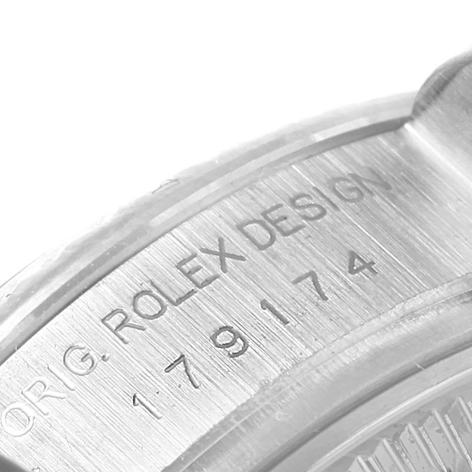 The image shows a close-up view of the engraved serial number and "ROLEX DESIGN" text on a Rolex Datejust 179174 Women's Stainless Steel Black Dial 179174 Women's Stainless Steel Black Dial watch case.