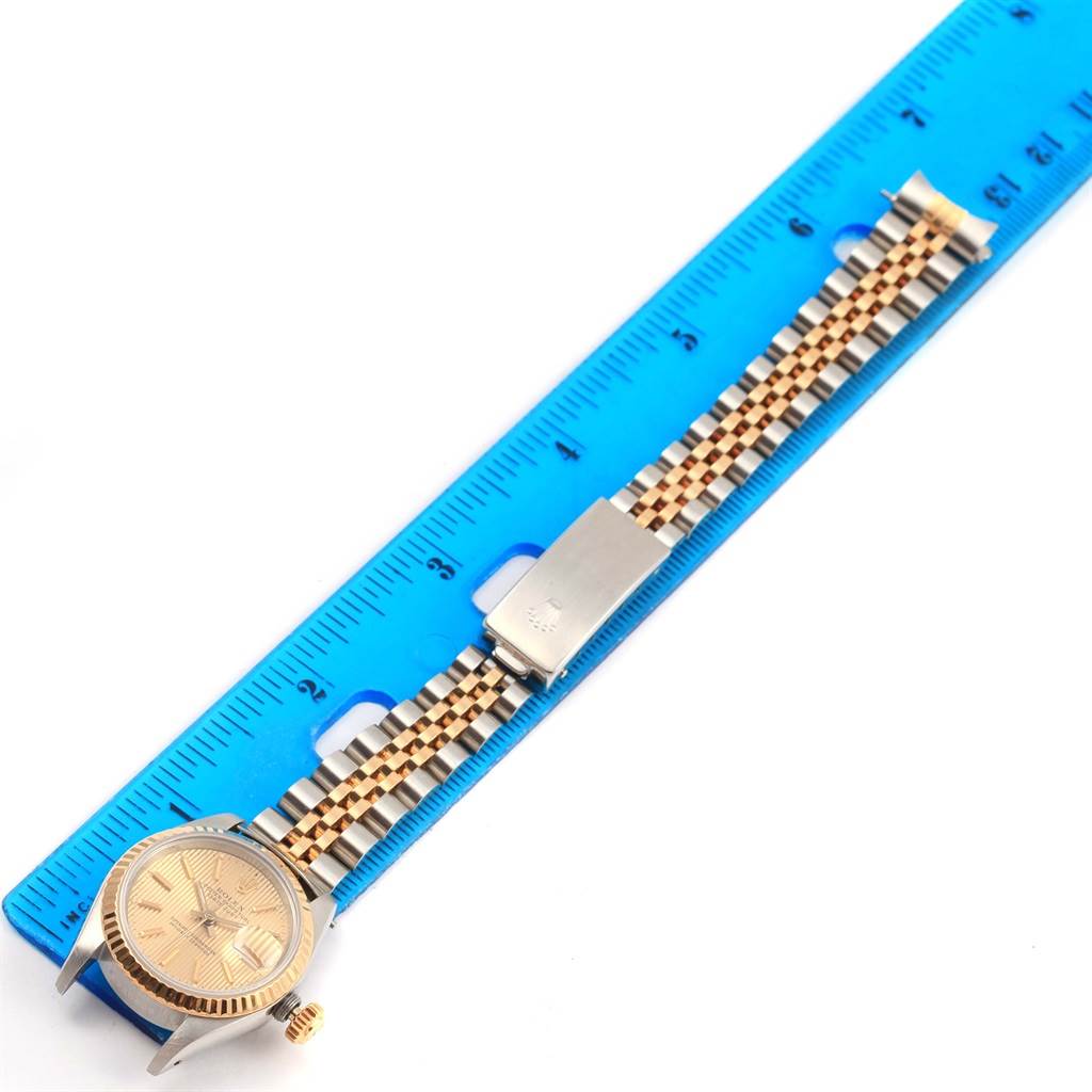 The image shows a Rolex Datejust 69173 Women's Stainless Steel Champagne Dial 69173 Women's Stainless Steel Champagne Dial watch placed next to a blue ruler, displaying the face, case, crown, and bracelet fully extended.