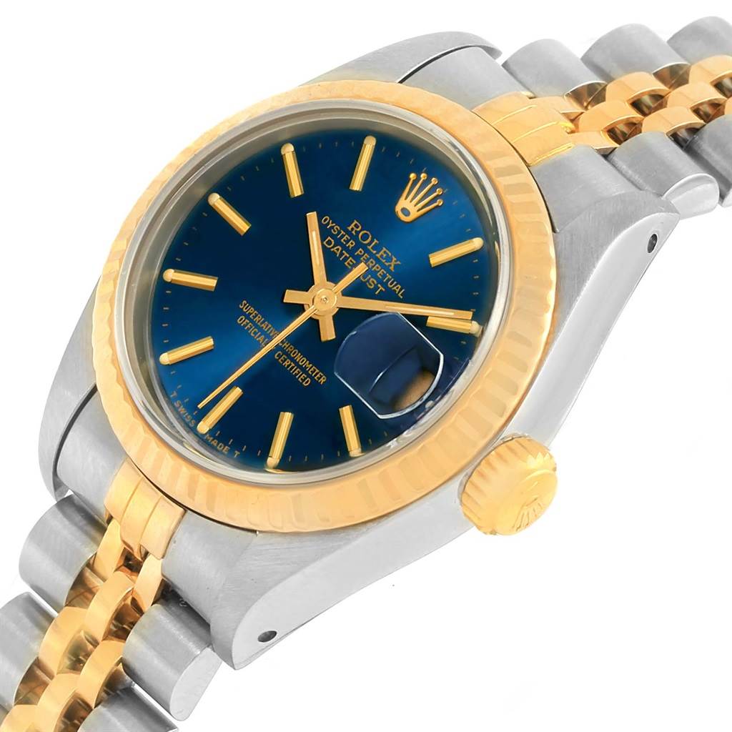 The image shows a close-up angle of a Rolex Datejust 69173 Women's Stainless Steel Blue Dial 69173 Women's Stainless Steel Blue Dial watch, highlighting its blue dial, gold fluted bezel, and two-tone bracelet.