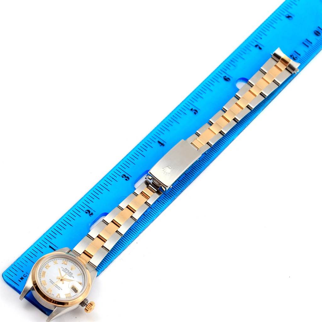 The Rolex Datejust 69163 Women's Stainless Steel Mother of Pearl Dial 69163 Women's Stainless Steel Mother of Pearl Dial watch is shown from a top view, displaying the face, crown, and entire bracelet next to a ruler for scale.