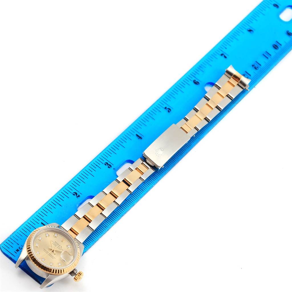 This image shows a Rolex Datejust 69173 Women's Stainless Steel Champagne Dial 69173 Women's Stainless Steel Champagne Dial watch laid flat next to a blue ruler, displaying the watch face, bracelet, and clasp.