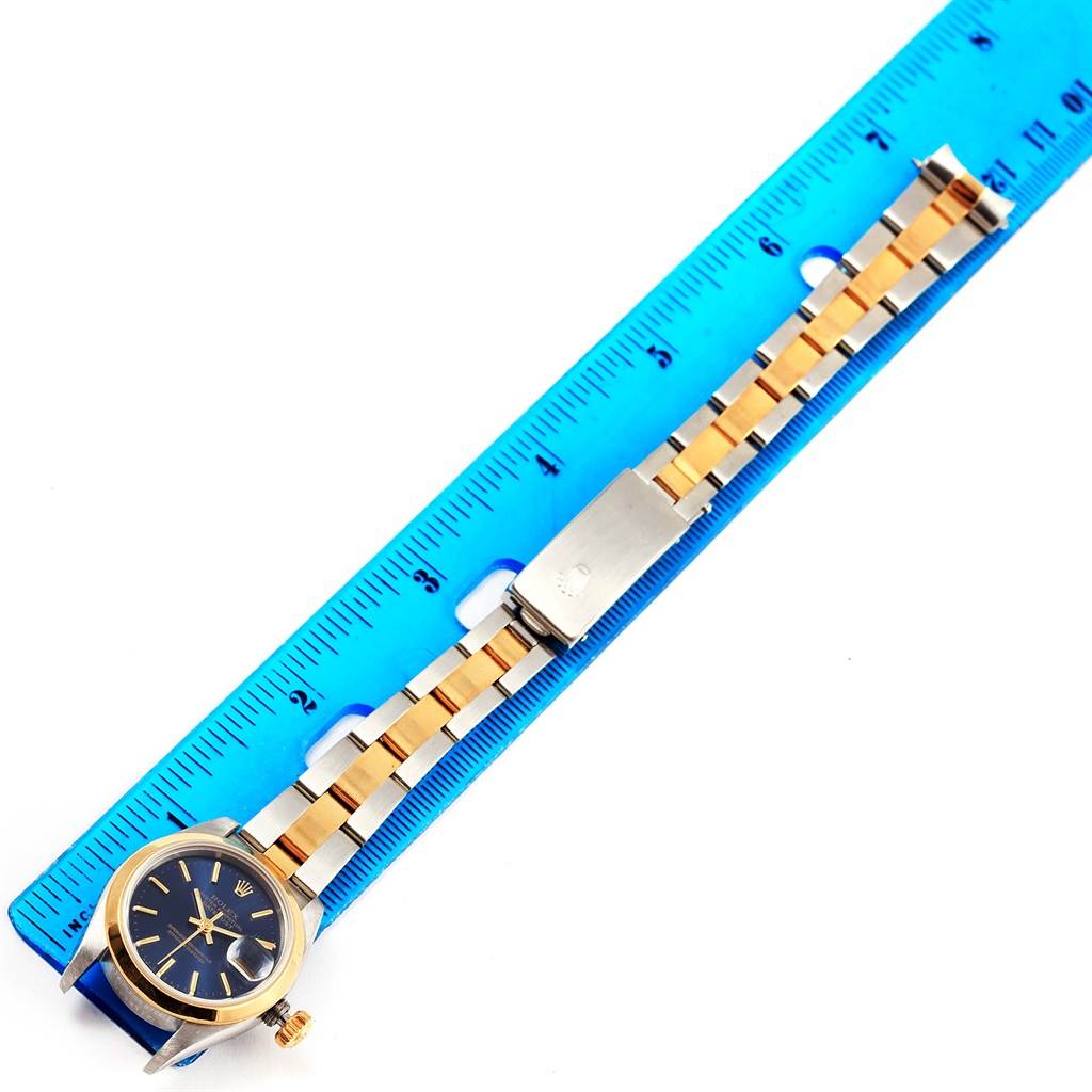 The Rolex Datejust 69163 Women's Stainless Steel Blue Dial 69163 Women's Stainless Steel Blue Dial watch is shown flat with a full view of the bracelet alongside a blue ruler for measurement.