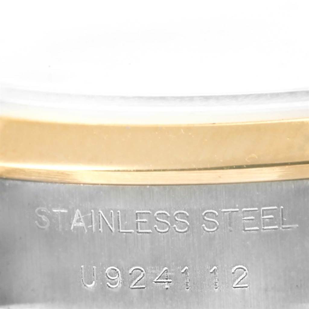 This image shows a close-up of the side of a Rolex Datejust 69163 Women's Stainless Steel Blue Dial 69163 Women's Stainless Steel Blue Dial watch, focusing on the stainless steel and gold part with engraved details.