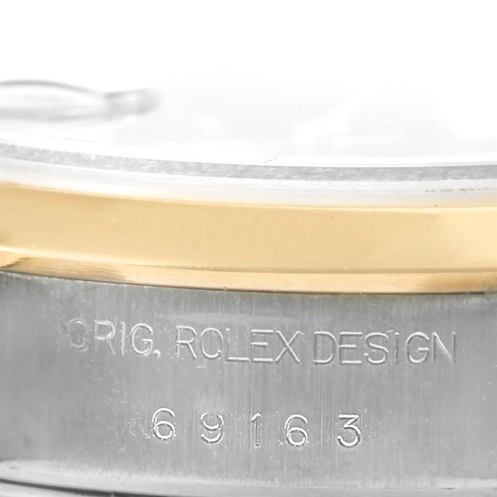 The image shows an angled close-up of the side of a Rolex Datejust 69163 Women's Stainless Steel Blue Dial 69163 Women's Stainless Steel Blue Dial watch, displaying the engraved serial number and some bezel detail.