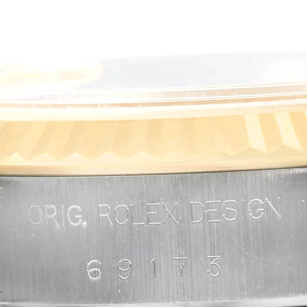 This close-up image of a Rolex Datejust 69173 Women's Stainless Steel Champagne Dial 69173 Women's Stainless Steel Champagne Dial watch shows part of the engraved case and the fluted bezel.