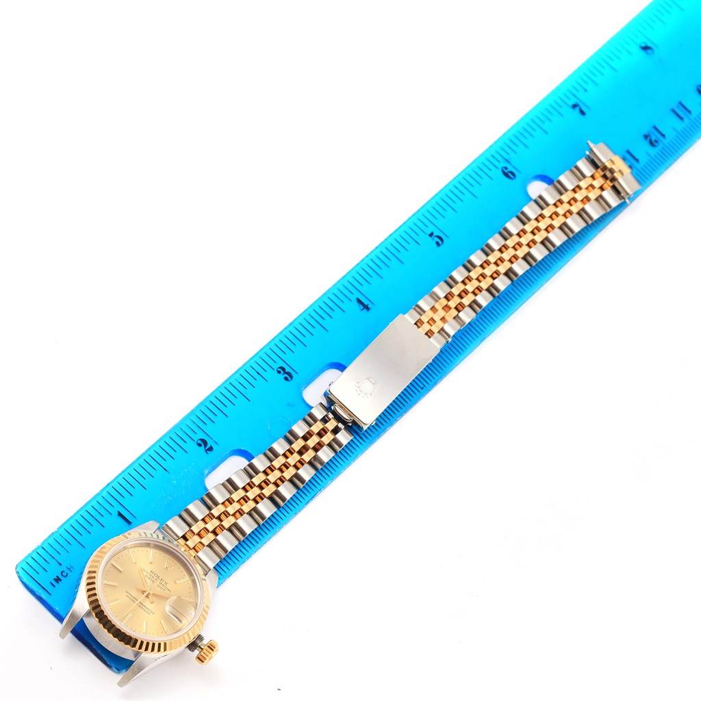 The image shows a Rolex Datejust 69173 Women's Stainless Steel Champagne Dial 69173 Women's Stainless Steel Champagne Dial watch laid flat with its gold/silver bracelet extended alongside a blue ruler for measuring.