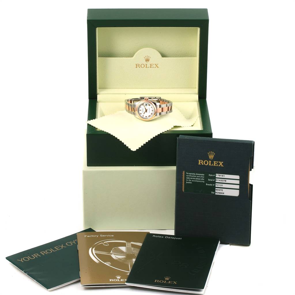 This image shows a Rolex Datejust 179161 Women's Steel and Gold (two tone) White Dial 179161 Women's Steel and Gold (two tone) White Dial watch in an open box with accompanying booklets and documents around it.