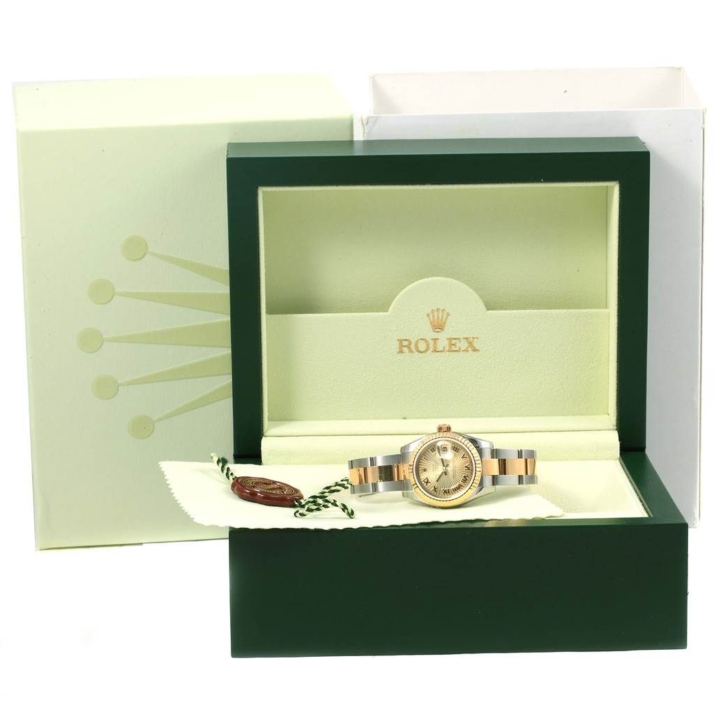 The image shows a Rolex Datejust 179173 Women's Steel and Gold (two tone) Champagne Dial 179173 Women's Steel and Gold (two tone) Champagne Dial watch in its green and beige box, viewed from the front with the watch and accessories visible.