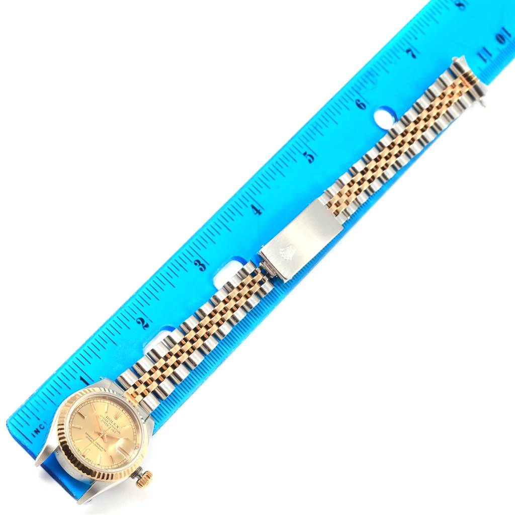 The image shows a Rolex Datejust 69173 Women's Stainless Steel Champagne Dial 69173 Women's Stainless Steel Champagne Dial watch with a close-up of its dial and bracelet placed next to a blue ruler.