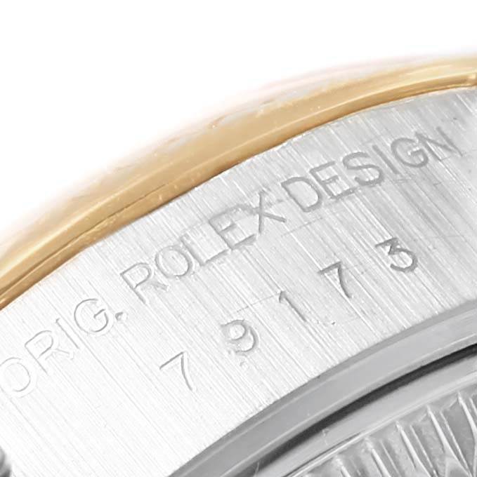 This image shows a close-up of the serial number and 'ROLEX DESIGN' engraving on the side of a Rolex Datejust 79173 Women's Steel and Gold (two tone) Silver Dial 79173 Women's Steel and Gold (two tone) Silver Dial watch case.