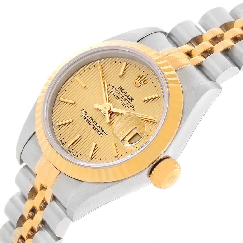 This Rolex Datejust 79173 Women's Steel and Gold (two tone) Champagne Dial 79173 Women's Steel and Gold (two tone) Champagne Dial watch is shown at a slight angle, displaying the gold-toned dial, fluted bezel, and part of its two-tone bracelet.
