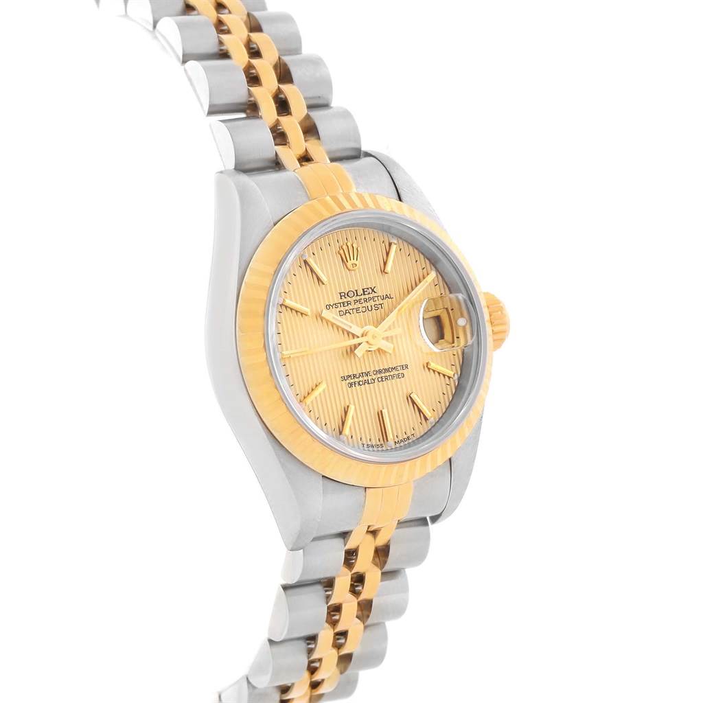 The image shows a side angle of a Rolex Datejust 79173 Women's Steel and Gold (two tone) Champagne Dial 79173 Women's Steel and Gold (two tone) Champagne Dial watch highlighting its gold fluted bezel and two-tone bracelet.
