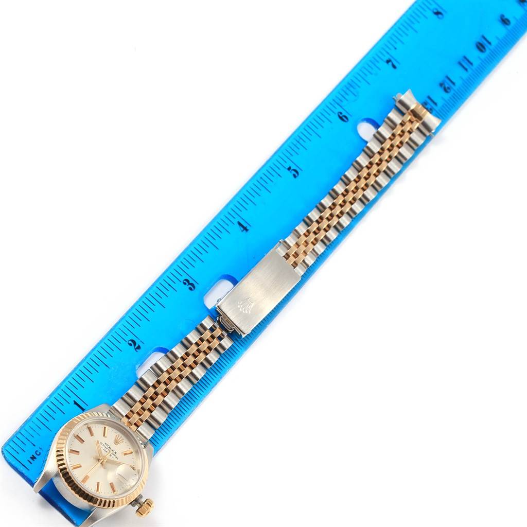 The image shows a Rolex Datejust 69173 Women's Stainless Steel Silver Dial 69173 Women's Stainless Steel Silver Dial watch laid flat next to a ruler, highlighting the face, crown, and bracelet with the clasp.