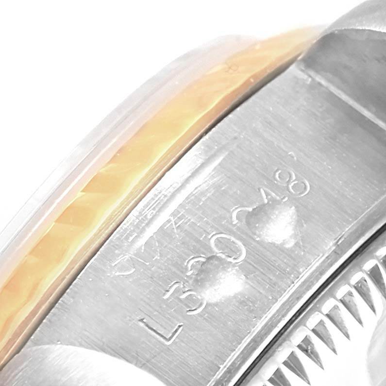 The image shows a close-up of the case edge of a Rolex Datejust 69173 Women's Stainless Steel Champagne Dial 69173 Women's Stainless Steel Champagne Dial with visible engraving, part of the bezel, and crystal.