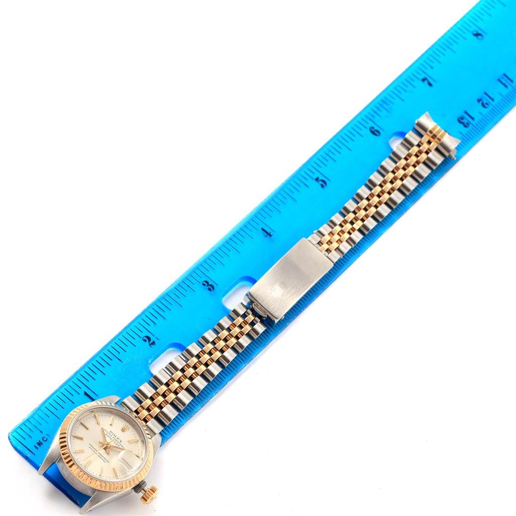 The image shows a Rolex Datejust 69173 Women's Stainless Steel Silver Dial 69173 Women's Stainless Steel Silver Dial watch laid flat against a blue ruler, highlighting its face and two-tone metal bracelet strap.