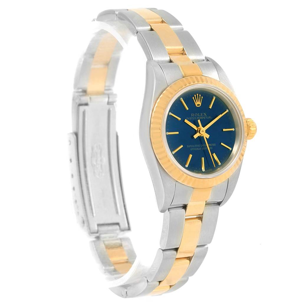 The Datejust Rolex watch is shown from a front left angle, highlighting its blue dial, gold fluted bezel, and two-tone bracelet.