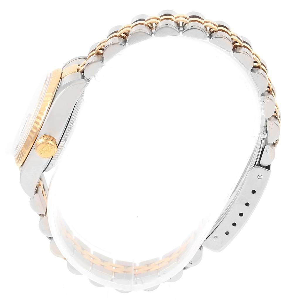 This side view of a Rolex Datejust 79173 Women's Steel and Gold (two tone) Champagne Dial 79173 Women's Steel and Gold (two tone) Champagne Dial watch highlights the crown, bezel, and two-tone bracelet.