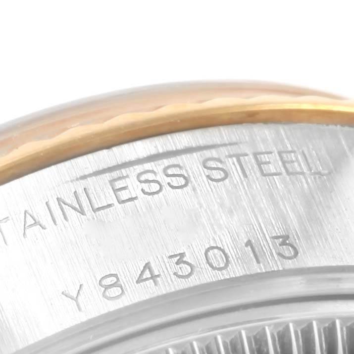 This image shows a close-up of the engraved casing on a Rolex Datejust 79173 Women's Steel and Gold (two tone) Champagne Dial 79173 Women's Steel and Gold (two tone) Champagne Dial watch, specifically the stainless steel and gold bezel.