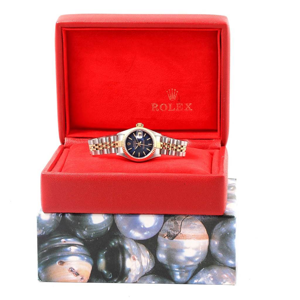 The Rolex Datejust 79173 Women's Steel and Gold (two tone) Blue Dial 79173 Women's Steel and Gold (two tone) Blue Dial watch is shown from the front, displayed in an open red box with a clear view of its face and bracelet.