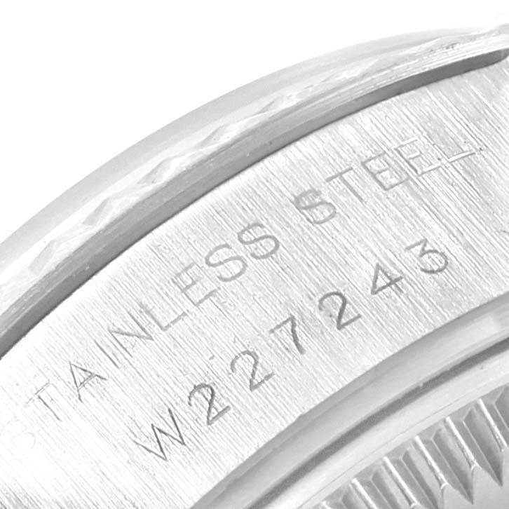The image shows a close-up of the engraved serial number and "STAINLESS STEEL" on the case of a Rolex Datejust 69174 Women's Stainless Steel White Dial 69174 Women's Stainless Steel White Dial watch.