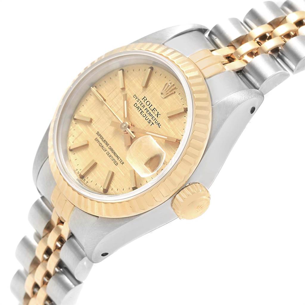 The image shows a side and partial top view of a Rolex Datejust 69173 Women's Stainless Steel Champagne Dial 69173 Women's Stainless Steel Champagne Dial watch, highlighting its gold bezel, dial, and two-tone bracelet.