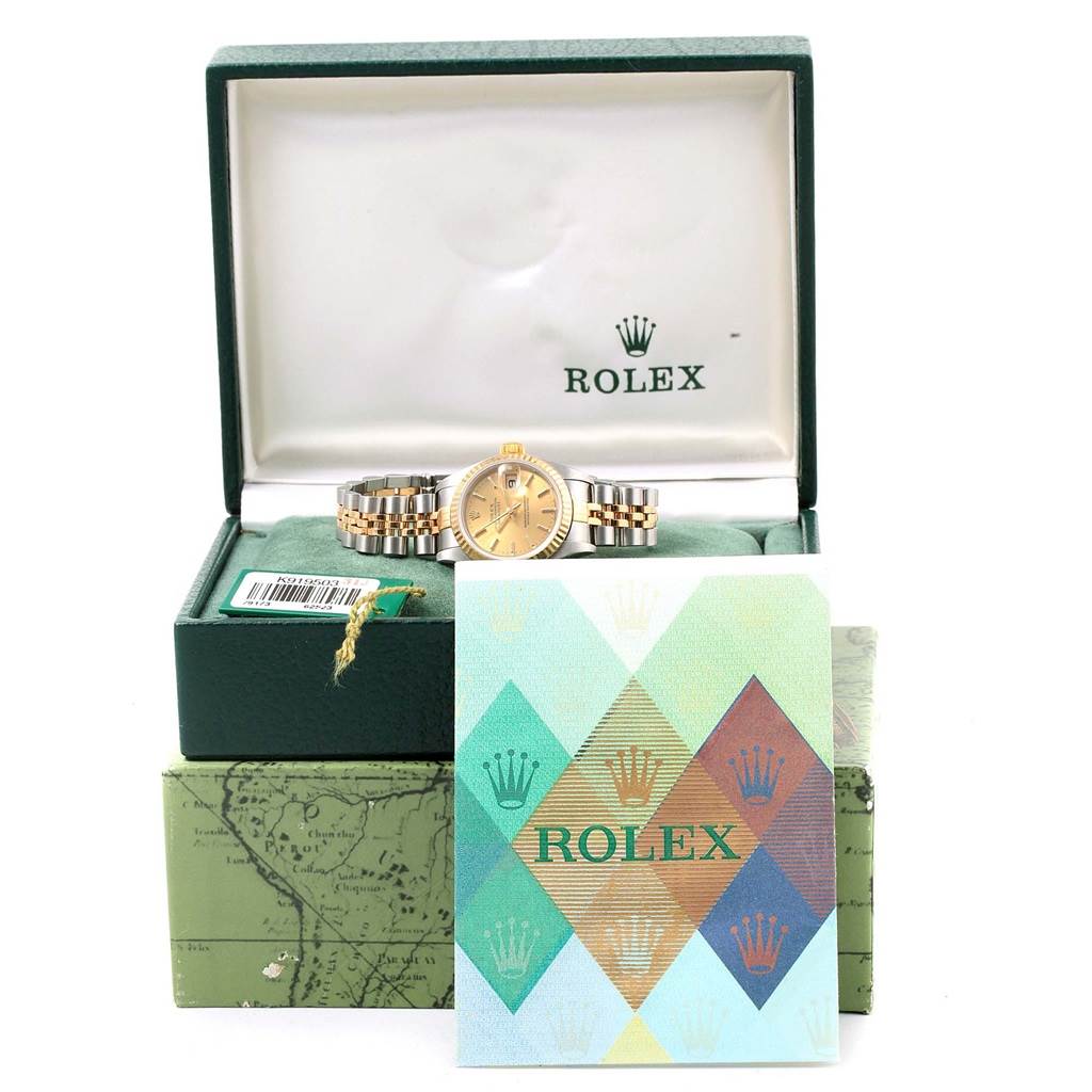 The Rolex Datejust 79173 Women's Steel and Gold (two tone) Champagne Dial 79173 Women's Steel and Gold (two tone) Champagne Dial watch is shown in its open box with accompanying documentation in front.