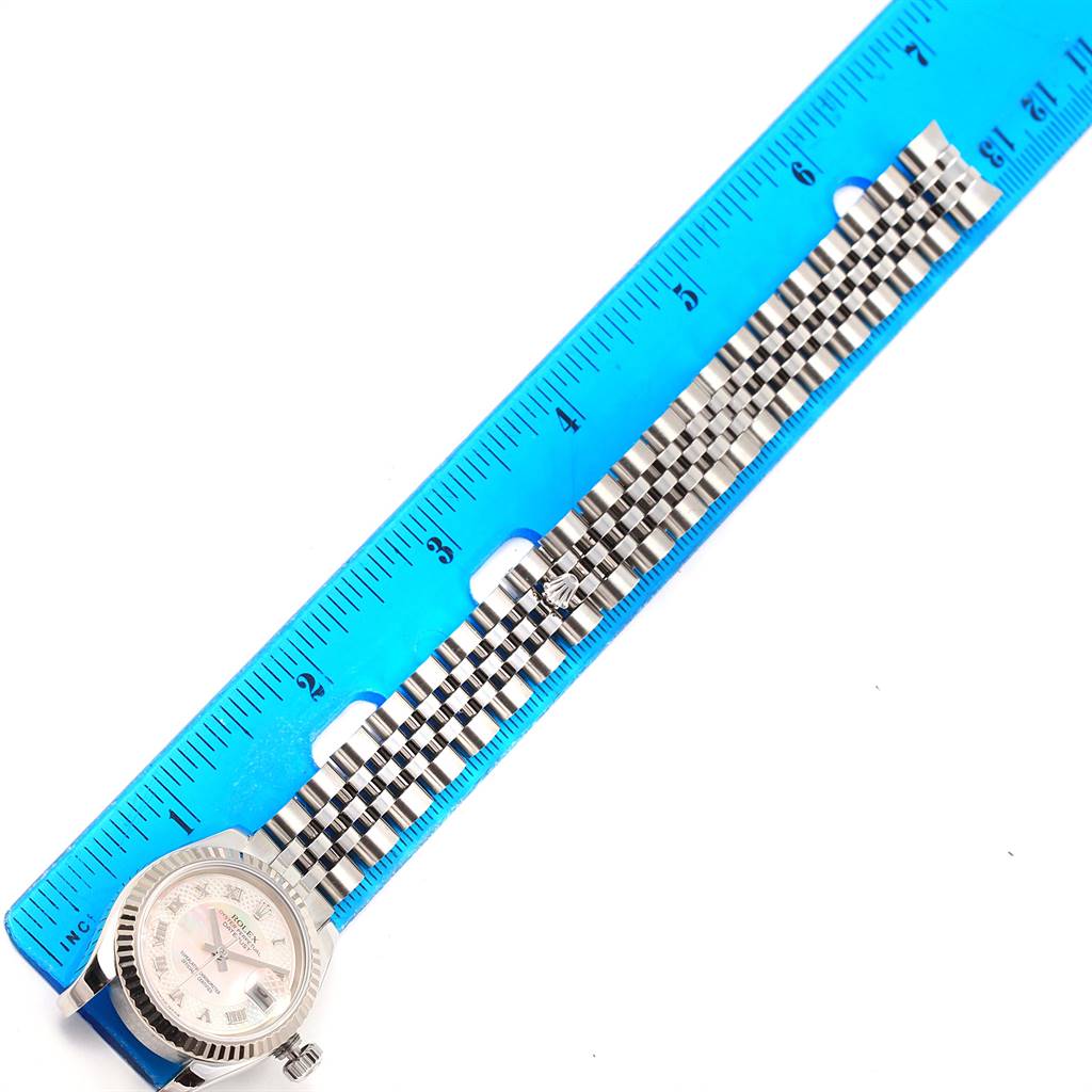 The Rolex Datejust 179174 Women's Stainless Steel Mother of Pearl Dial 179174 Women's Stainless Steel Mother of Pearl Dial watch is shown flat, displaying its dial, bezel, and bracelet alongside a blue ruler for scale.