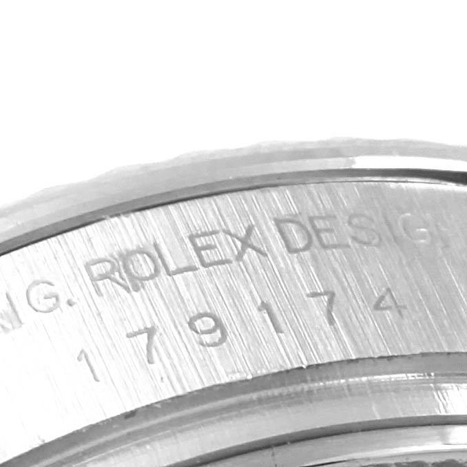 The image shows a close-up angle of the side of a Rolex Datejust 179174 Women's Stainless Steel Mother of Pearl Dial 179174 Women's Stainless Steel Mother of Pearl Dial watch, highlighting the engraved text and serial number.