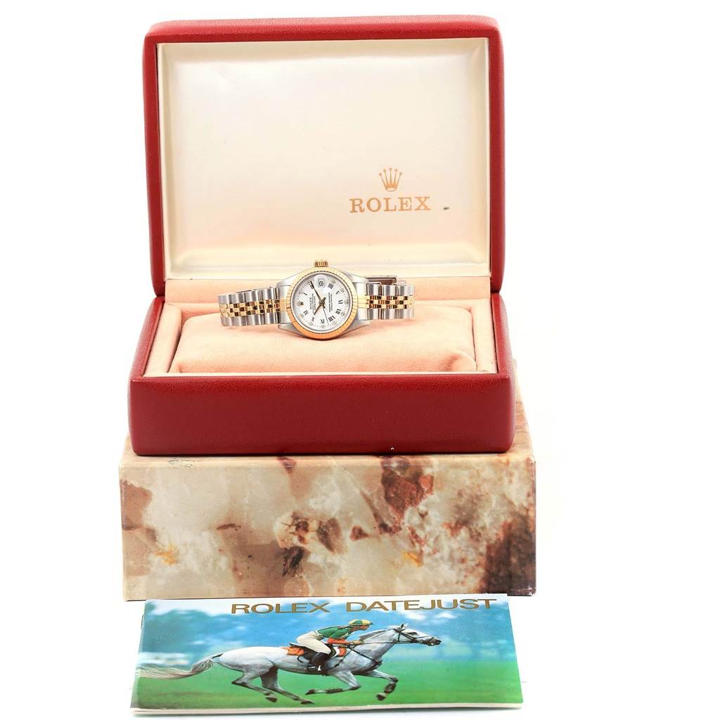 The Rolex Datejust 69173 Women's Stainless Steel White Dial 69173 Women's Stainless Steel White Dial watch is displayed in an open box with a booklet placed in front.