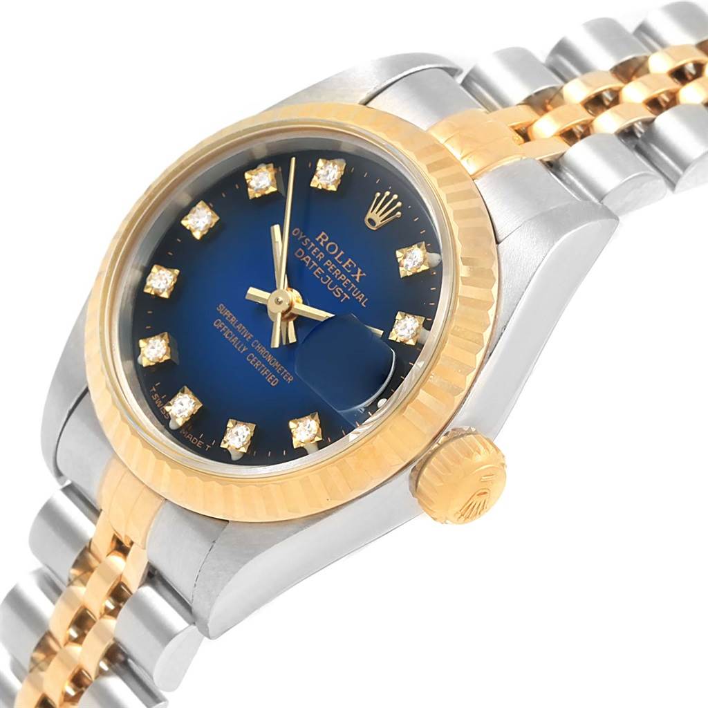 This image showcases a Rolex Datejust 69173 Women's Stainless Steel Blue Dial 69173 Women's Stainless Steel Blue Dial watch featuring a blue diamond-studded dial, gold fluted bezel, and two-tone Jubilee bracelet at an angled view.